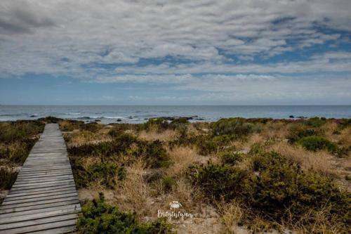 a wooden pathway leading to the ocean on a beach at Granite View in St Helena Bay