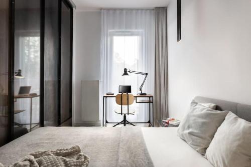 a bedroom with a bed and a desk with a lamp at Deluxe apartment in City Center, Steam Park in Krakow