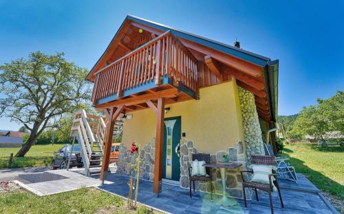 a small house with a deck and a table and chairs at Betlehem Resort in Zgornje Gorje