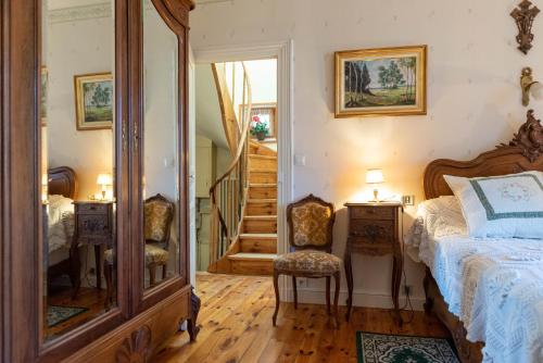 a bedroom with a bed and a mirror and a staircase at La Maison de Mireille in Le Puy en Velay