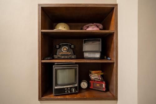 una estantería de madera con TV y otros artículos. en 安樓文旅Enzo House, en Keelung