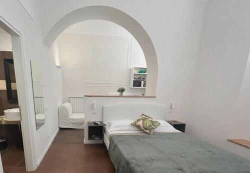 Habitación blanca con cama y espejo en Eccelso Suites, en Roma