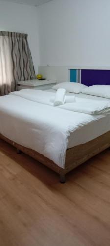 a bed with white sheets and pillows in a room at MYHome@Langkawi in Pantai Cenang
