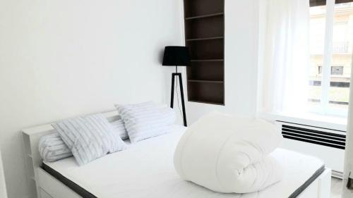 - une chambre blanche avec un canapé blanc et une fenêtre dans l'établissement Modern 1 bed flat - Near Arc de Triomphe & Champs Elysees, à Paris