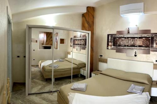 a hotel room with two beds and a mirror at Penthouse di charme in borgo vicino al mare in Nulvi