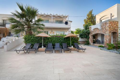 a patio with chairs and umbrellas in front of a building at Costa Sariyaz Hotel Bodrum in Bodrum City
