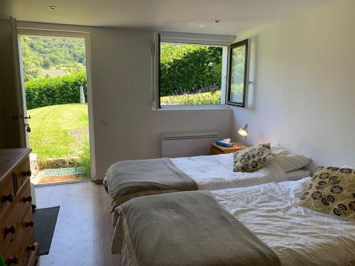 - 2 lits dans une chambre avec 2 fenêtres dans l'établissement Tranquil apartment surrounded by nature & golf, à Écharvine