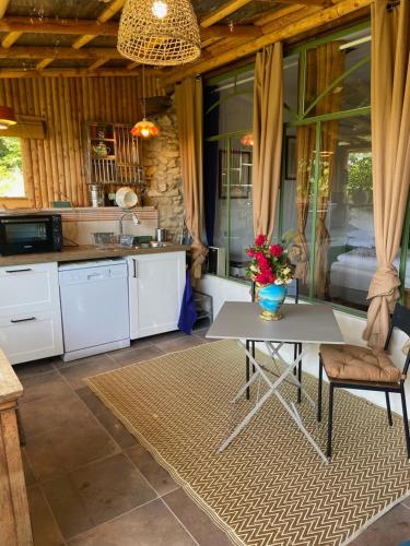 - une cuisine avec une table et des fleurs dans l'établissement GITE PATCHAMAMA, à Pierrerue
