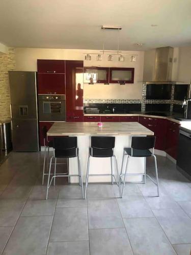 une cuisine avec une grande table et des chaises en bois dans l'établissement Appartement de kiki, à Éloyes