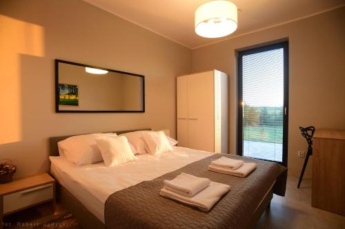 ein Schlafzimmer mit einem Bett mit zwei Handtüchern darauf in der Unterkunft Willa Skrzatusz in Skrzatusz