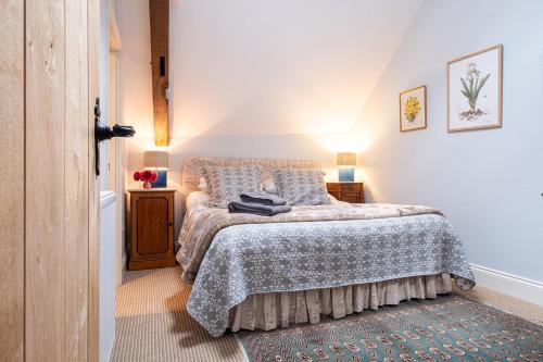 a bedroom with a bed with a blanket and a rug at Deerpark Barn in Daventry