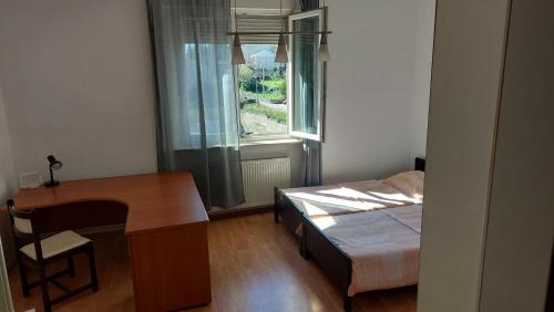 a bedroom with a desk and a bed and a window at Nika in Rijeka