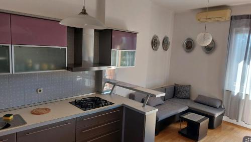 a kitchen with a stove and a couch in a room at Nika in Rijeka