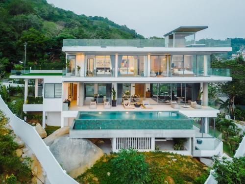 a large white house with a swimming pool at Villa Nordic Star Seaview Near Kata Beach in Kata Beach