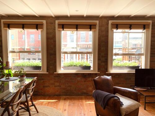a living room with windows and a table and chairs at Your Private Hoxton Apartment Sleeps 3 London Zone 1 in London