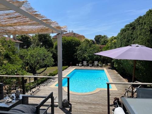 una piscina con sombrilla junto a una casa en Cannes charming villa private pool garden 1,7 kms from sea and sand beach en Le Cannet