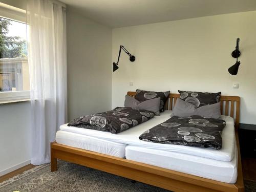 a bedroom with a bed with two pillows and a window at Top ausgestattete Wohnung in Traumlage mit grandioser Aussicht in Bühlertal