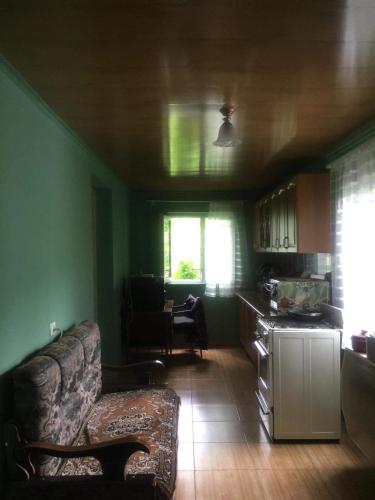 a living room with a couch and a kitchen at MACHABELl in Ambrolauri