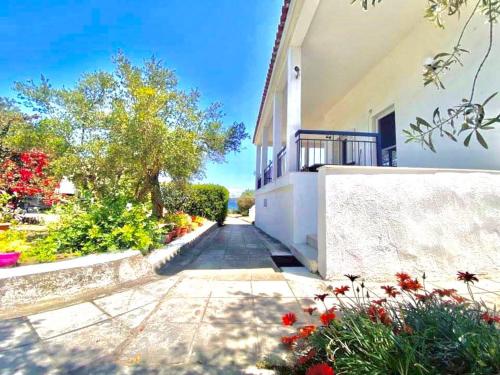 a house with a walkway and flowers at Casa Santa Agua in Ammouliani