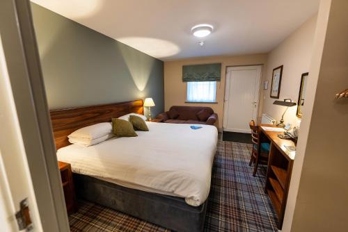 a bedroom with a bed and a desk in a room at The Lindisfarne Inn - The Inn Collection Group in Beal
