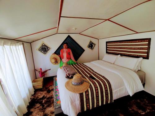 Eine Frau auf einem Bett in einem Zimmer in der Unterkunft CHUYPAS DEL TITICACA in Puno