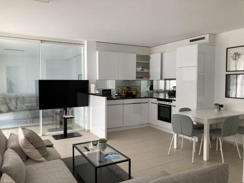 Dolcevita Locarno في لوكارنو: غرفة معيشة مع أريكة وطاولة مع تلفزيون