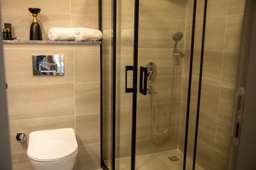 a bathroom with a toilet and a glass shower at Monalisa Hotels KUŞADASI in Kusadası