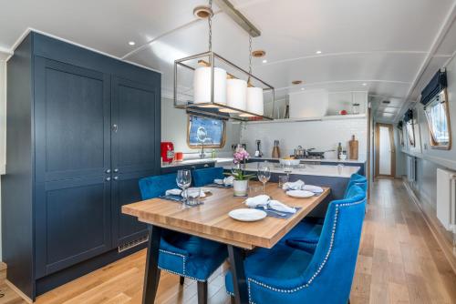 a dining room with a table and blue chairs at ALTIDO Stylish barge near Canary Wharf in London