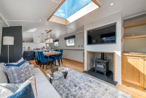 a living room with a couch a table and a fireplace at ALTIDO Stylish barge near Canary Wharf in London