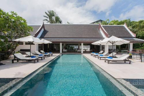 a swimming pool with lounge chairs and umbrellas at Katamanda - Villa Katamalee Private Pool near Kata Noi Beach in Kata Beach