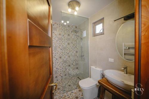 een badkamer met een toilet, een wastafel en een spiegel bij Bungalouri Balta Paradisul Pescarilor in Pufeşti