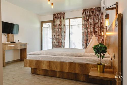 ein Schlafzimmer mit einem großen Bett und einem Fenster in der Unterkunft Bungalouri Balta Paradisul Pescarilor in Pufeşti