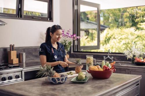 a woman standing in a kitchen with a bowl of fruit at Katamanda - Villa Katamalee Private Pool near Kata Noi Beach in Kata Beach