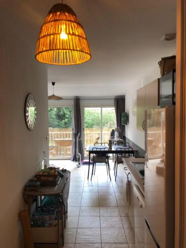 une cuisine avec une table et un grand éclairage dans l'établissement BEAU T2 - PISCINE CHAUFFEE, à Serra-di-Ferro