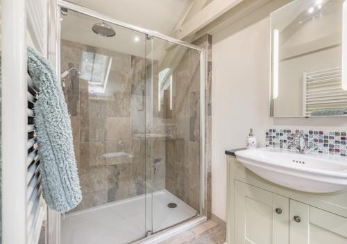 a bathroom with a shower and a sink at The Hayloft Dunmere in Bodmin