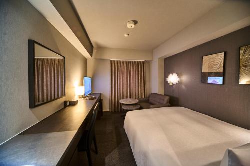a hotel room with a large bed and a desk at Roppongi Hotel S in Tokyo