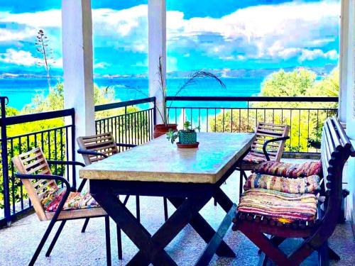 a table and chairs on a porch with a view of the ocean at Casa Santa Agua in Ammouliani