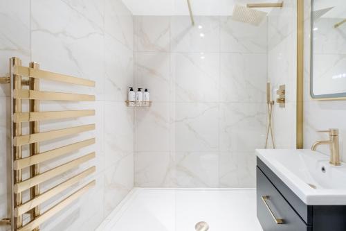 a white bathroom with a shower and a sink at Luxury 1 Bedroom Apartment in Central London in London