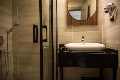 W łazience znajduje się umywalka i lustro. w obiekcie MONALİSA HOTELS w mieście Kusadası