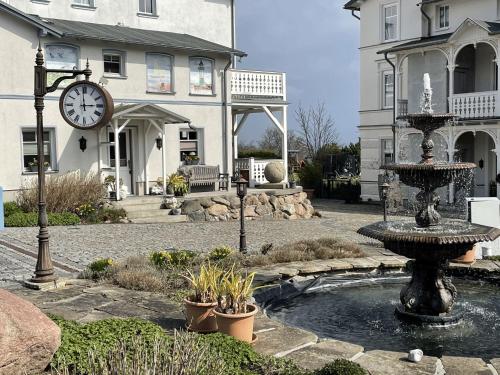 a clock on the side of a building with a fountain at Villa Seestern - Ferienhaus mit Meerblick in Sassnitz