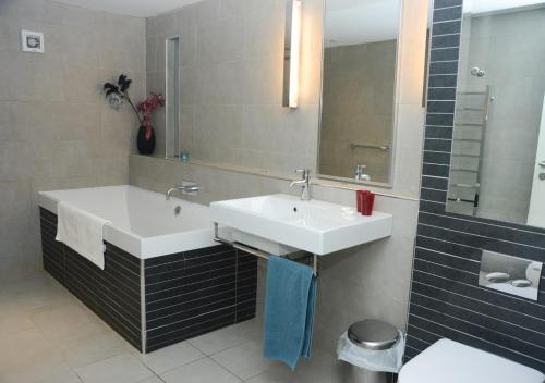 ein Badezimmer mit einem weißen Waschbecken und einem Spiegel in der Unterkunft The Barn in Middleton