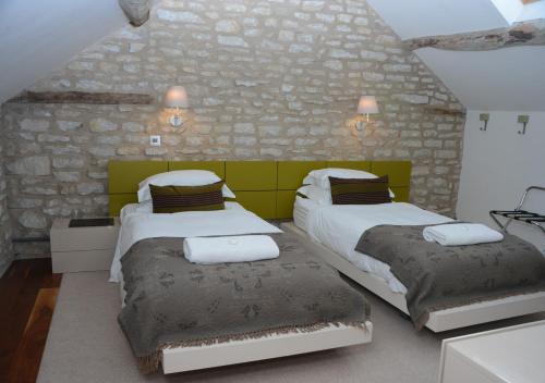1 Schlafzimmer mit 2 Betten und einer Steinmauer in der Unterkunft The Barn in Middleton