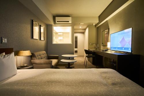 a hotel room with a bed and a desk with a computer at Roppongi Hotel S in Tokyo