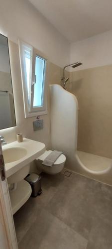 a bathroom with a sink and a toilet and a mirror at Casa Di Kimolos in Kimolos