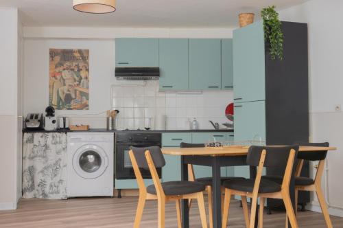 a kitchen with a table and chairs and a washing machine at Bergerie du centre ville - 1 chambre, équipement bébé, wifi et draps inclus in Dieppe