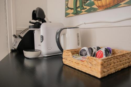 a basket of shoes sitting on a table next to a coffee maker at Bergerie du centre ville - 1 chambre, équipement bébé, wifi et draps inclus in Dieppe