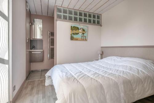 une chambre avec un lit blanc et une fenêtre dans l'établissement Longère rénovée à 500m du Centre de Pornic pour 4, à Pornic