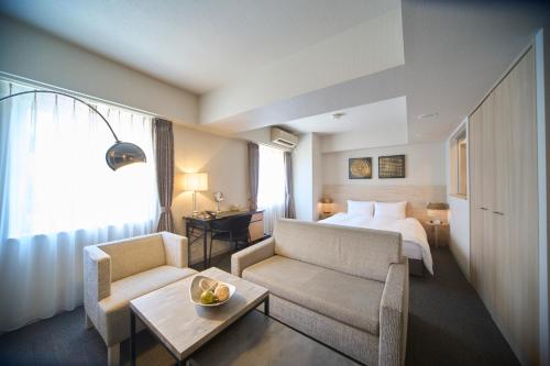 a hotel room with a bed and a couch and a table at Roppongi Hotel S in Tokyo
