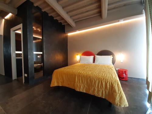 a bedroom with a bed with a yellow bedspread at Vistaperdue in Peccioli