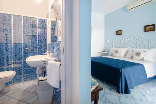 a bathroom with a bed and a sink and a toilet at BnB Le Isole in Ischia